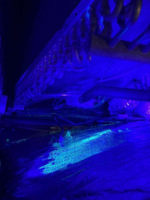 Responded to no cooling complaint on 9-month-old equipment. Performed UV leak detection on refrigerant system, inspecting copper line sets, connections, and evaporator coil assembly. UV light revealed potential leak indicators at connection points and pipe bends. Documented findings with UV photography showing fluorescent dye response on refrigerant lines and evaporator coil for further evaluation and repair recommendations.