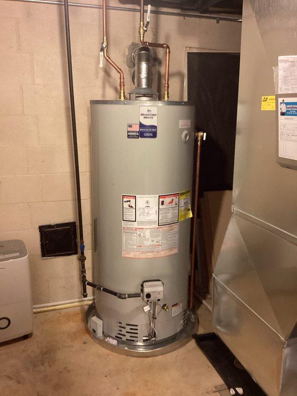 Completed installation of a 75-gallon Bradford White natural gas atmospheric vent water heater with new chimney liner system. Removed existing water heater, installed new unit with proper copper piping connections, pressure relief valve, gas control assembly, and venting infrastructure to ensure code-compliant operation and safe exhaust of combustion gases.
