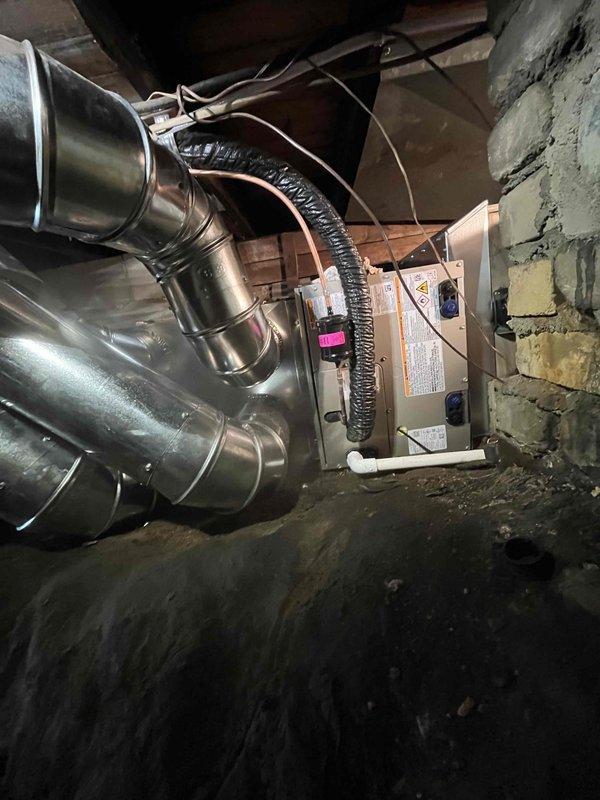 Complete HVAC system replacement performed, including installation of new outdoor condensing unit and indoor air handler. Removed existing equipment and installed Carrier brand outdoor unit on concrete pad with proper refrigerant line connections, electrical disconnect, and secure mounting. Indoor air handler positioned in basement utility area with metallic supply ductwork, flexible return ducting, and electrical wiring completed per manufacturer specifications. System tested and verified operational.