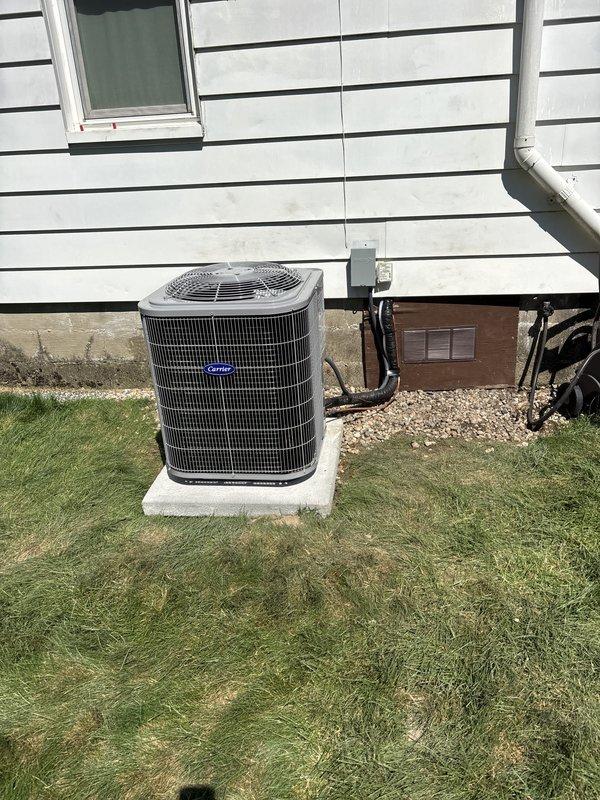 Complete HVAC system replacement performed, including installation of new outdoor condensing unit and indoor air handler. Removed existing equipment and installed Carrier brand outdoor unit on concrete pad with proper refrigerant line connections, electrical disconnect, and secure mounting. Indoor air handler positioned in basement utility area with metallic supply ductwork, flexible return ducting, and electrical wiring completed per manufacturer specifications. System tested and verified operational.