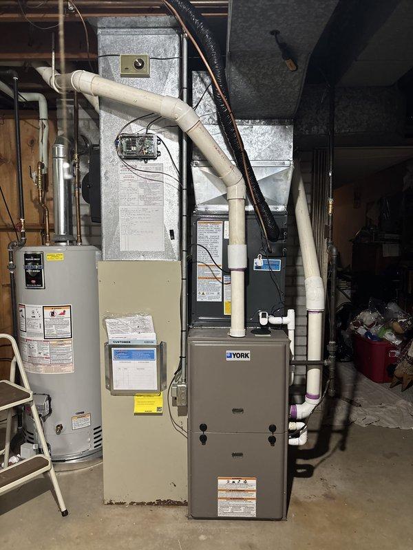Completed full air conditioning system replacement including outdoor condensing unit and indoor air handler. Installed new York HVAC equipment with proper refrigerant lines, electrical connections, and condensate drainage. Mounted outdoor unit on existing concrete pad adjacent to building with appropriate clearances, connected electrical disconnect, and routed refrigerant lines through brick wall penetration. Indoor installation included air handler placement in basement mechanical area with integration to existing ductwork, PVC venting configuration, and proper electrical terminations. System was pressure tested, evacuated, charged to manufacturer specifications, and verified operational with all safety controls functioning correctly.