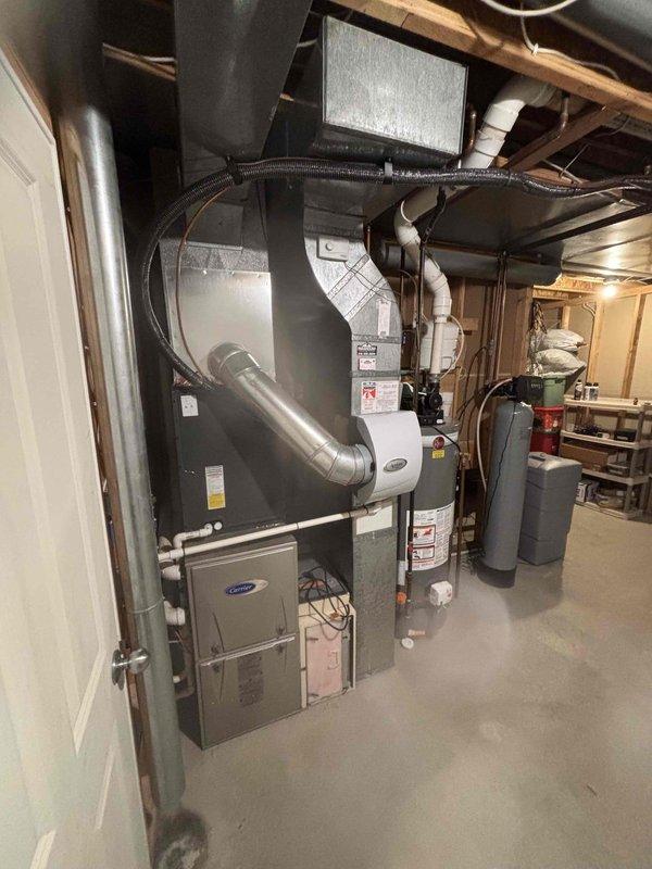 Conducted site assessment of basement HVAC system to evaluate electronic air filter removal. Documented existing Carrier furnace installation with connected ductwork, Aprilaire humidifier, and current air filtration configuration. Photographed equipment layout and measurements to provide accurate estimate for electronic air filter removal and any necessary ductwork modifications.