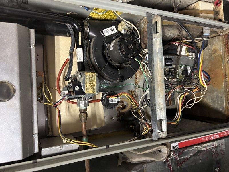 Responded to service call for air conditioning system experiencing intermittent operation and complete failure during hot weather conditions. Upon arrival, found system had been manually restarted by customer and was currently running. Performed comprehensive diagnostic inspection of indoor air handler and outdoor condensing unit. Inspected blower motor assembly, gas valve connections, electrical wiring, and capacitor for signs of failure or degradation. Found significant accumulation of dirt, dust, and debris on outdoor unit components and electrical connections, indicating lack of recent maintenance. Documented existing conditions with photographs showing interior cabinet components, wiring connections, and outdoor unit electrical assembly with visible contamination. System components showed normal operational wear with environmental exposure evident throughout. Evaluated blower motor operation, capacitor condition, and electrical connections for proper function and safety concerns.