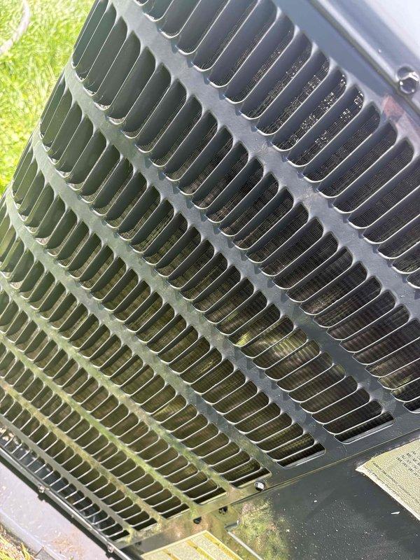 # CP-Cooling Problem Resolution

Responded to service call for AC system running continuously but struggling to maintain temperature, with indoor conditions rising to 72°F and climbing. Upon arrival, performed visual inspection of 4-year-old outdoor condensing unit.

Inspection revealed heavy accumulation of yellow-green pollen and organic debris significantly coating the condenser coil fins, particularly concentrated on multiple sections of the coil surface. This contamination was restricting proper airflow through the heat exchanger, reducing the system's cooling capacity and efficiency. External housing also showed signs of weathering and discoloration consistent with outdoor exposure.

Documented equipment condition through photographic evidence showing the extent of coil contamination and overall unit condition. The debris buildup was substantial enough to impair heat transfer and cause the system performance issues reported by the customer.

Cleaning and restoration of condenser 