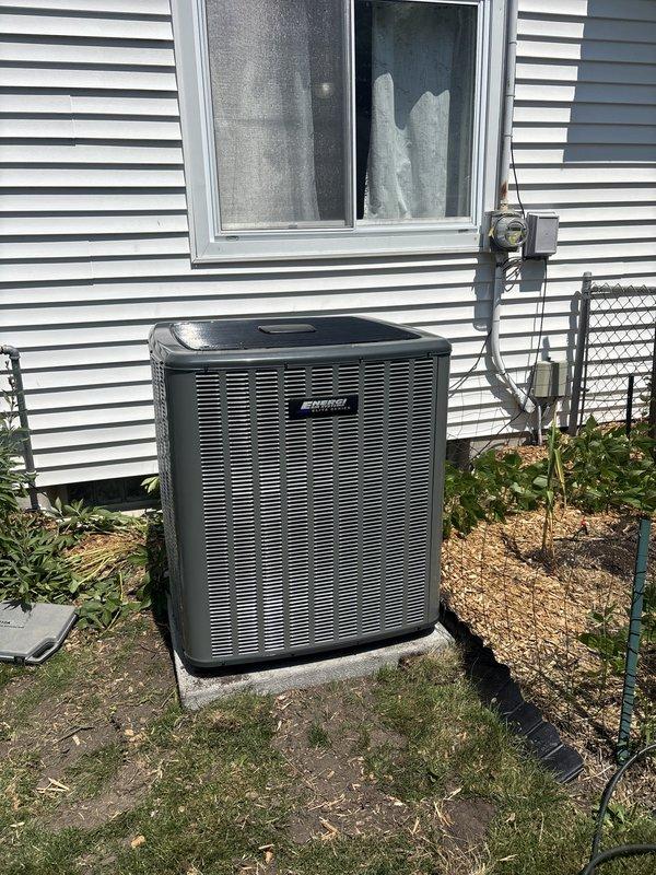 Completed full residential air conditioning system replacement including outdoor condensing unit and indoor air handler. Removed existing equipment and installed new condenser on concrete pad against exterior wall with proper electrical disconnect box and conduit connections. Installed new air handler in basement utility space with associated ductwork connections and electrical controls. Verified proper refrigerant lines, drainage, and all electrical connections to code. System tested and operational upon completion.