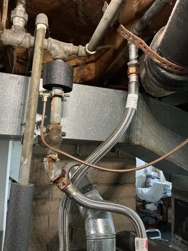 Completed annual cooling system tune-up on 16-year-old air conditioning unit. Performed comprehensive inspection of all mechanical components, verified refrigerant levels, checked electrical connections, and tested system operation. Documented existing plumbing infrastructure including condensate drainage system with pump assembly and aging copper supply lines showing corrosion, which may require future attention.