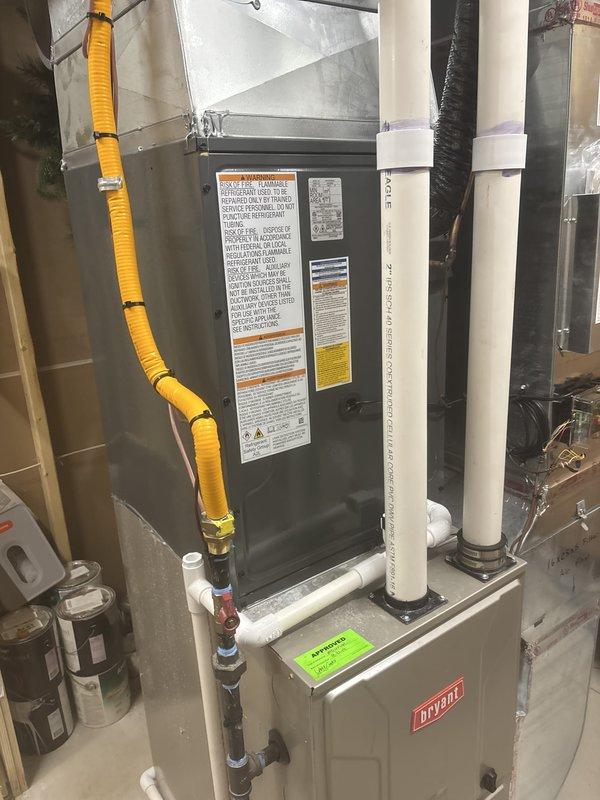 Completed full HVAC system replacement in basement utility area. Removed existing equipment and installed new Bryant furnace with matching air handler unit. Ran new yellow flexible gas line with proper connections and secured mounting. Installed white PVC condensate drainage lines with insulation wrap where required. Mounted all equipment to code specifications with appropriate brackets and hardware. Connected ductwork to new system and verified all electrical connections. System tested and operational upon completion.