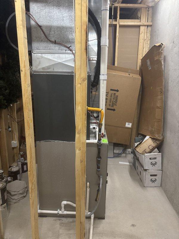 Completed full HVAC system replacement in basement utility area. Removed existing equipment and installed new Bryant furnace with matching air handler unit. Ran new yellow flexible gas line with proper connections and secured mounting. Installed white PVC condensate drainage lines with insulation wrap where required. Mounted all equipment to code specifications with appropriate brackets and hardware. Connected ductwork to new system and verified all electrical connections. System tested and operational upon completion.