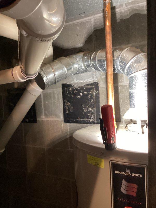 # NC-No Cool Service Call

Responded to air conditioning system with frozen evaporator coils preventing proper cooling. Customer had already initiated thaw procedure by switching unit off with fan running. Assessed AC unit (less than 10 years old) to determine root cause of coil freezing, which typically indicates restricted airflow, low refrigerant charge, or system operational issues.

During site inspection, customer reported additional concern regarding water heater leak. Inspected 17-year-old Bradford White water heater and documented visible signs of moisture and age-related deterioration. Photographed water heater installation, including plumbing connections, surrounding ductwork, and evidence of leak. Captured images showing unit's condition, label information, and utility room setup with exposed mechanical systems.

Provided customer with assessment findings and prepared quote for water heater repair versus replacement options given the unit's age and condition. Documented bot