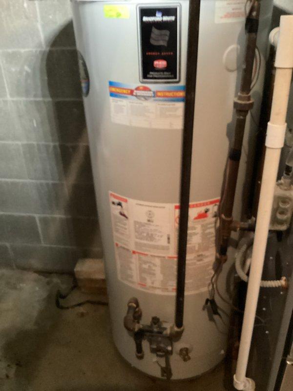 # NC-No Cool Service Call

Responded to air conditioning system with frozen evaporator coils preventing proper cooling. Customer had already initiated thaw procedure by switching unit off with fan running. Assessed AC unit (less than 10 years old) to determine root cause of coil freezing, which typically indicates restricted airflow, low refrigerant charge, or system operational issues.

During site inspection, customer reported additional concern regarding water heater leak. Inspected 17-year-old Bradford White water heater and documented visible signs of moisture and age-related deterioration. Photographed water heater installation, including plumbing connections, surrounding ductwork, and evidence of leak. Captured images showing unit's condition, label information, and utility room setup with exposed mechanical systems.

Provided customer with assessment findings and prepared quote for water heater repair versus replacement options given the unit's age and condition. Documented bot