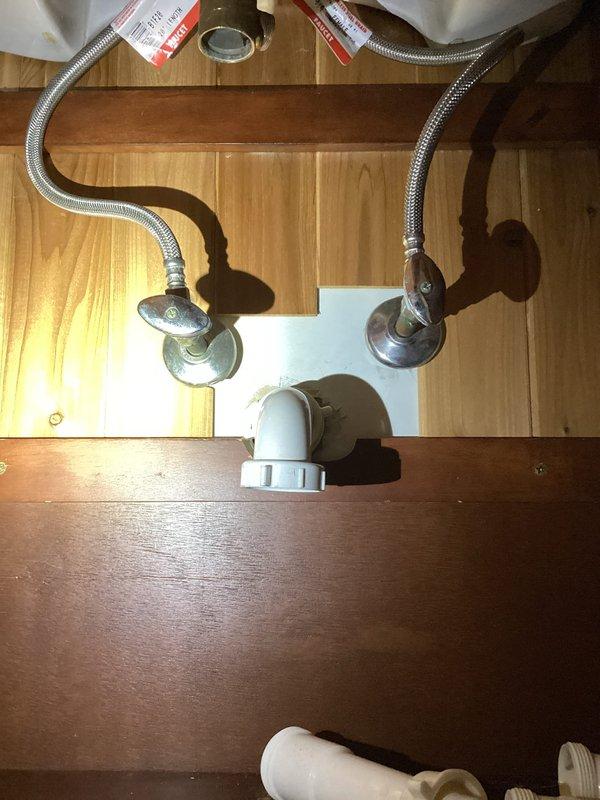 Responded to upstairs bathroom sink drain issue in 30-year-old home. Upon inspection, found faulty drain assembly requiring replacement. Removed existing P-trap and drain components, installed new white plastic P-trap assembly with proper connections to existing water supply lines. Verified all connections secure, tested for leaks, and confirmed proper drainage function. System restored to full working order.