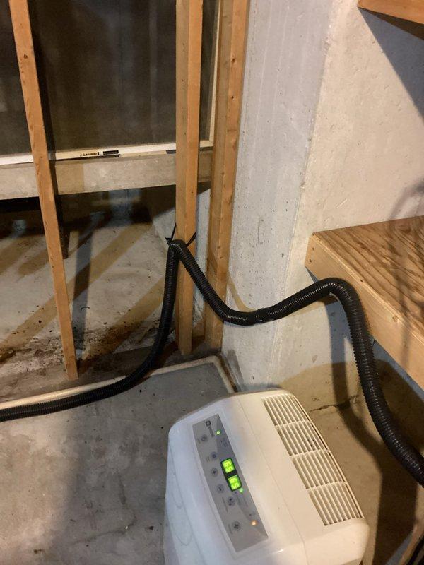 Responded to early availability request for toilet replacement and sump pump evaluation. Upon arrival, assessed basement conditions and found active moisture issues with water pooling around existing sump pump pit. Client-supplied toilet was installed to replace existing fixture. Conducted thorough inspection of sump pump system, which showed signs of inadequate water management with visible standing water and moisture accumulation on concrete floor. Dehumidifier was already in operation to address ongoing moisture concerns. Evaluated drainage system configuration, including pump discharge lines and pit functionality. Documented basement conditions with photographs showing water staining on concrete, exposed foundation walls with wooden framing, and current water management equipment setup. Provided client with assessment findings and recommendations for sump pump replacement to improve water removal efficiency and prevent future moisture-related issues in the basement space.