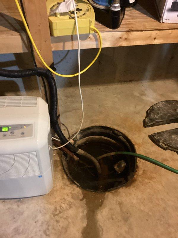 Responded to early availability request for toilet replacement and sump pump evaluation. Upon arrival, assessed basement conditions and found active moisture issues with water pooling around existing sump pump pit. Client-supplied toilet was installed to replace existing fixture. Conducted thorough inspection of sump pump system, which showed signs of inadequate water management with visible standing water and moisture accumulation on concrete floor. Dehumidifier was already in operation to address ongoing moisture concerns. Evaluated drainage system configuration, including pump discharge lines and pit functionality. Documented basement conditions with photographs showing water staining on concrete, exposed foundation walls with wooden framing, and current water management equipment setup. Provided client with assessment findings and recommendations for sump pump replacement to improve water removal efficiency and prevent future moisture-related issues in the basement space.