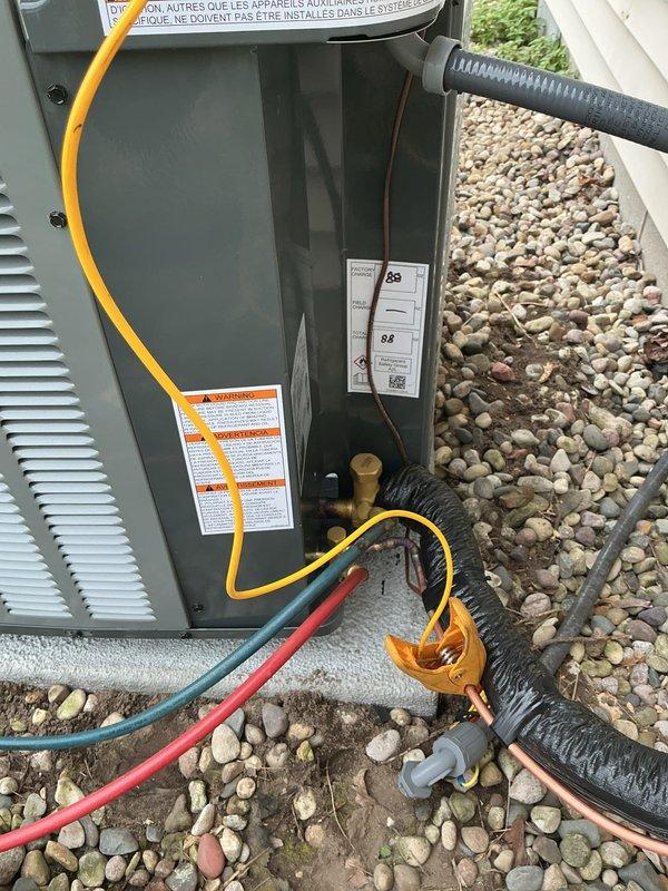 Completed full air conditioning system replacement at residential property. Installed new HVAC condensing unit on existing gravel pad against exterior wall with beige vinyl siding, ensuring proper placement and levelness on concrete foundation. Connected refrigerant lines (suction and liquid lines) with appropriate insulation, ran electrical supply conduit and wiring to unit, and mounted electrical disconnect boxes on exterior siding per code requirements. Verified all refrigerant line connections are secure and properly brazed, confirmed electrical connections meet manufacturer specifications and local electrical codes. System startup performed successfully with all operating parameters within normal range.