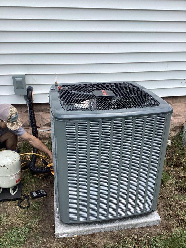 Successfully completed add-on air conditioning installation to existing forced-air heating system. Installed new outdoor condenser unit on concrete pad with proper clearances from structure, mounted electrical disconnect box on exterior wall with appropriate conduit routing. Connected refrigerant lines and performed vacuum and charging procedures using manifold gauges to manufacturer specifications. Inside basement mechanical room, integrated new evaporator coil with existing Comfortmaker furnace system, installed condensate drainage piping using PVC with proper pitch and connections. Verified all electrical connections at both indoor and outdoor units, tested system startup and operation. Confirmed proper airflow, refrigerant pressures, and temperature split across evaporator coil. System operating efficiently with all safety controls functioning as designed.