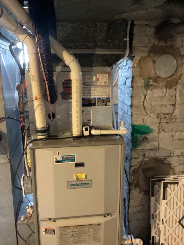 Successfully completed add-on air conditioning installation to existing forced-air heating system. Installed new outdoor condenser unit on concrete pad with proper clearances from structure, mounted electrical disconnect box on exterior wall with appropriate conduit routing. Connected refrigerant lines and performed vacuum and charging procedures using manifold gauges to manufacturer specifications. Inside basement mechanical room, integrated new evaporator coil with existing Comfortmaker furnace system, installed condensate drainage piping using PVC with proper pitch and connections. Verified all electrical connections at both indoor and outdoor units, tested system startup and operation. Confirmed proper airflow, refrigerant pressures, and temperature split across evaporator coil. System operating efficiently with all safety controls functioning as designed.