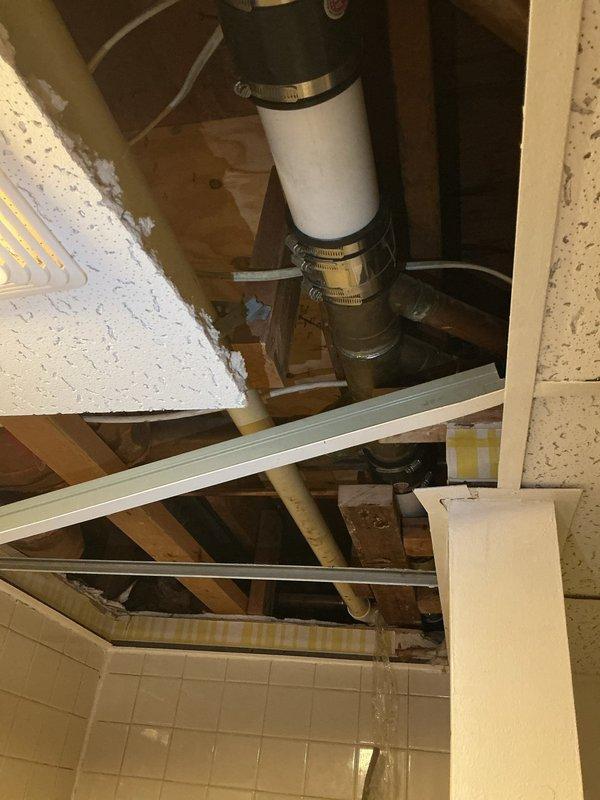 Completed stack-only replacement in residential ceiling cavity, removing existing deteriorated plumbing stack and installing new white PVC pipe assembly with proper coupling connections and securing clamps. Accessed work area through ceiling panel opening, connected new vertical drain stack to existing metal ductwork and lower plumbing system, ensuring proper alignment and watertight seals throughout installation.