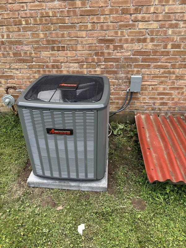 Completed full air conditioning system replacement including outdoor condensing unit and indoor air handler. Removed existing equipment and installed new HVAC system with proper refrigerant line connections, electrical disconnect, and condensate drainage. Positioned outdoor unit on concrete pad against exterior brick wall with appropriate clearances. Installed indoor air handler in basement mechanical room with black flexible ductwork connections and white PVC condensate piping. Verified all electrical connections, tested system operation, and confirmed proper cooling functionality upon completion.