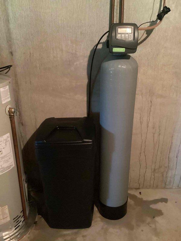 Responded to no hot water complaint. Upon arrival, inspected Bradford White water heater and associated plumbing system in basement utility area. Evaluated water heater operation, electrical connections, and gas supply. Confirmed water softener and filtration system were functioning properly with digital control head displaying normal operation. Checked copper supply lines, shutoff valves, and verified proper water flow through the system. Diagnosed issue and restored hot water service to the residence.