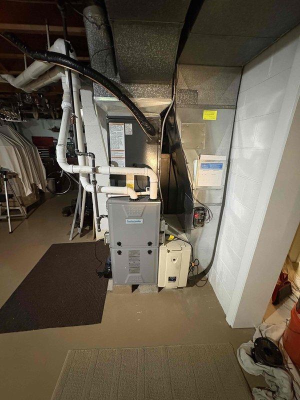 Completed full air conditioning system replacement including outdoor condenser unit and indoor air handler. Removed existing equipment and installed new Amana condenser unit on exterior concrete pad with proper electrical disconnect and conduit connections. Installed new furnace/air handler in basement mechanical room with associated ductwork connections, PVC condensate drainage piping, and electrical components. Verified all refrigerant line sets, ductwork transitions, and insulation were properly secured. System tested and confirmed operational with proper airflow and cooling performance.
