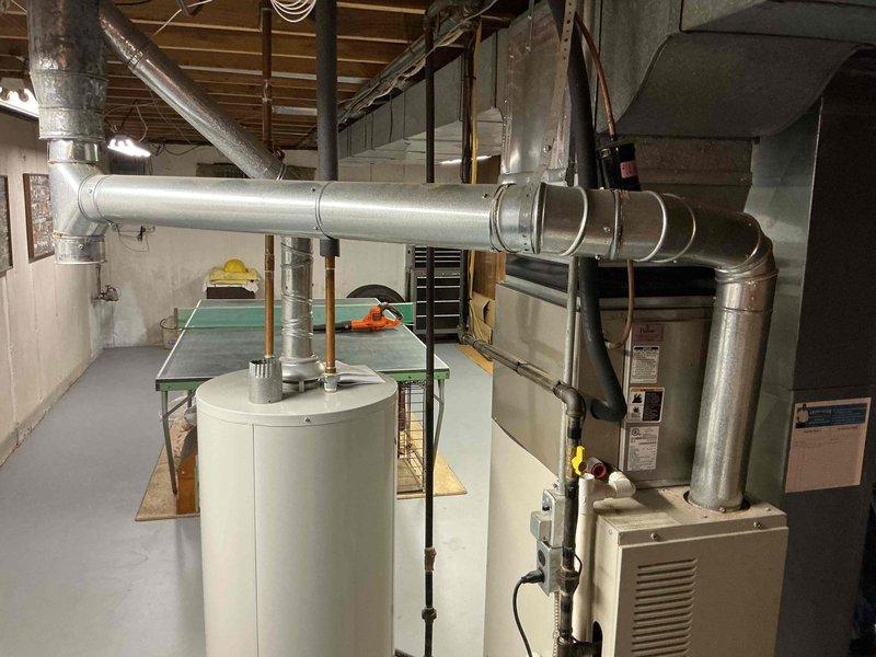 Responded to no hot water complaint at residential property. Upon inspection, found 11-year-old water heater with active leak from bottom of tank and visible corrosion, with rusty water pooled on concrete floor around base of unit. Water heater had reached end of serviceable life with internal tank failure causing the leak. Documented equipment condition and leak location with photos. Advised customer of findings and recommended full water heater replacement due to tank integrity failure.