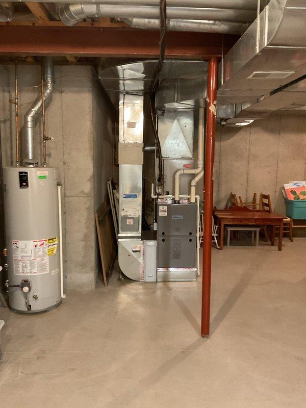Responded to no-cooling call on 21-year-old Bryant system where furnace fan was operating but outdoor unit showed no activity. Performed diagnostic evaluation of split system HVAC equipment located in basement utility area. Documented equipment condition and system configuration with photos showing furnace, air handler, and associated ductwork installation. Provided estimate for necessary repairs to restore outdoor unit operation and complete system functionality.