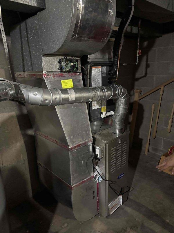 Completed full residential air conditioning system installation including outdoor condenser unit and indoor air handler components. Installed Carrier furnace system with integrated cooling coil in basement utility area, connected to new plenum and flexible ductwork distribution system. Mounted outdoor condensing unit on concrete pad with proper clearances, ran electrical conduit from meter box to equipment, and completed all refrigerant line connections between indoor and outdoor components. Verified proper airflow, tested system operation, and confirmed all electrical connections meet code requirements.