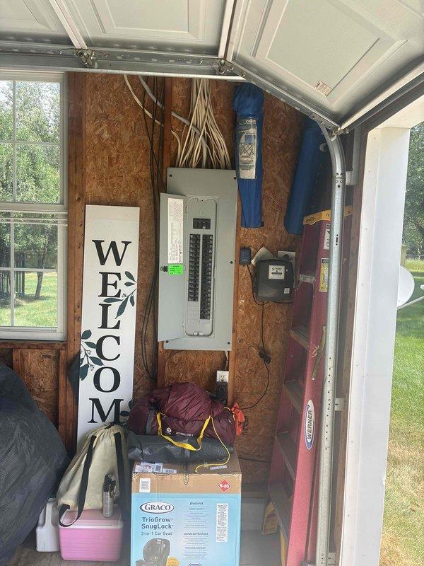 Conducted on-site assessment for whole home generator installation at a 26-year-old residential property. Evaluated existing electrical infrastructure, including main service panel located in detached garage with OSB interior walls. Documented current electrical panel configuration with multiple circuit breakers and existing wiring runs to determine integration requirements for automatic transfer switch and generator connection. Photographed electrical service equipment and garage layout to develop comprehensive installation proposal for standby generator system capable of providing whole-house backup power during utility outages.