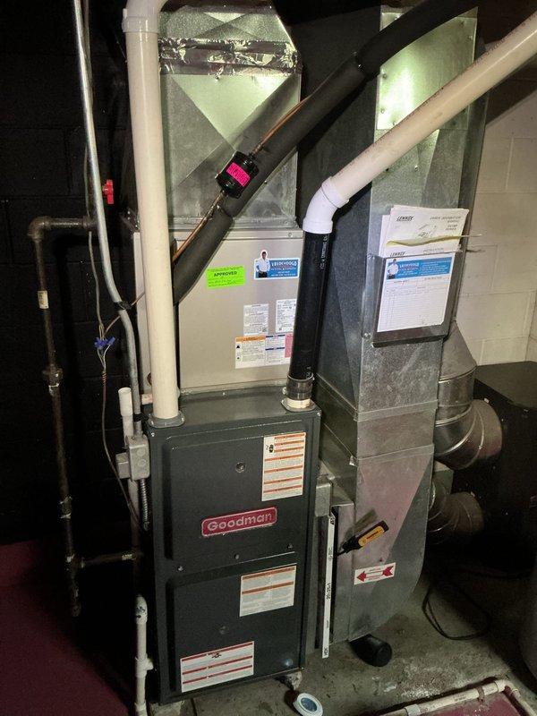 Responded to no-cooling complaint on residential split system installed in 2020. Upon arrival, confirmed air handler was operating but system was not producing cool air throughout the home. Performed diagnostic assessment of Goodman furnace and evaporator coil assembly located in basement utility area. Inspected refrigerant lines, electrical connections, and condensate drainage system. Verified blower operation and airflow through ductwork. Documented equipment condition and system configuration with photos for service records. System requires further evaluation of outdoor condensing unit and refrigerant charge levels to determine root cause of cooling failure and complete necessary repairs.