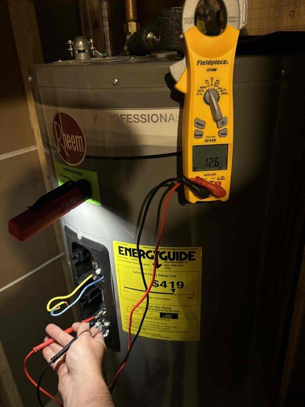 Responded to water heater issue on 4-year-old Rheem Professional unit with previous repair history. Performed electrical diagnostics using multimeter, testing voltage at heating element terminals (126V reading) and measuring amperage draw (12.1A reading) at blower motor assembly to verify proper operation. Completed system evaluation and discussed repair options versus replacement due to recurring problems with the unit.