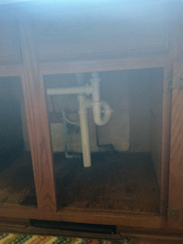 Responded to kitchen sink drain clog in utility/laundry area. Accessed plumbing system through crawl space opening to inspect and clear blockage in PVC drain line. Successfully restored proper drainage function and verified system operation.