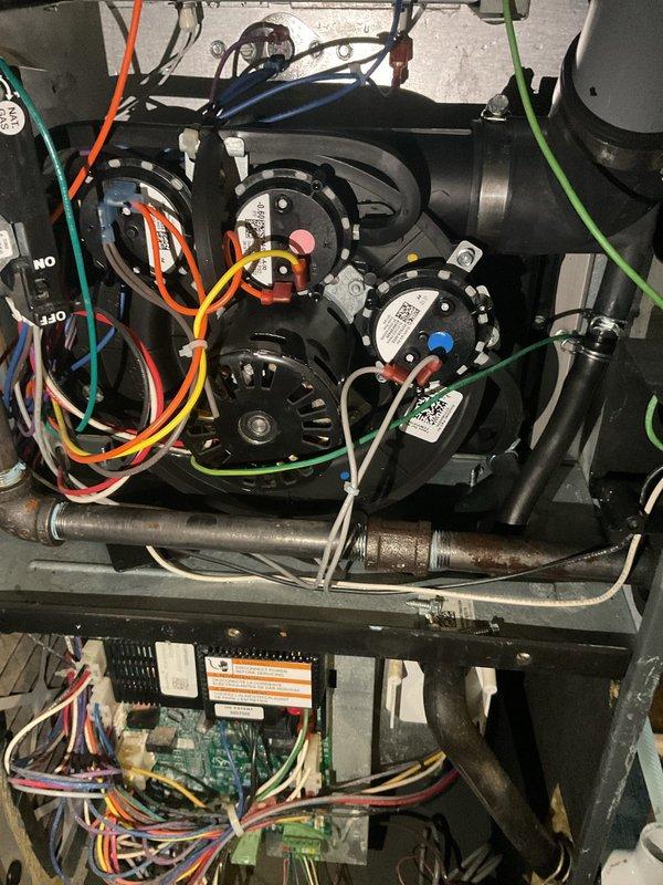 Responded to no cooling call where unit had sustained water damage affecting both furnace and water heater. Upon inspection, found water intrusion had compromised control boards and electrical components within the HVAC system. Documented internal condition of unit showing dual green circuit boards with multiple wire connections, blower assembly, and associated electrical components. Assessed damage to determine extent of water exposure on control systems and mechanical components. Photographed affected areas for documentation and warranty purposes.
