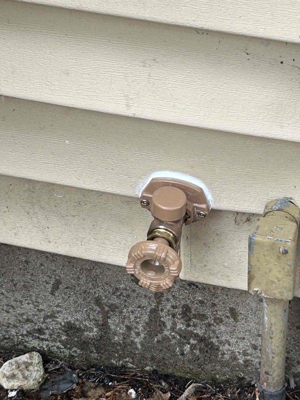Replaced exterior hose bib (outdoor water spigot) on building's exterior wall. Installed new frost-free spigot with brass fittings and protective insulation wrap at wall penetration point, ensuring proper connection to existing copper water supply lines in attic space above.