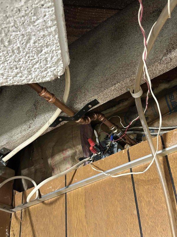 Replaced exterior hose bib (outdoor water spigot) on building's exterior wall. Installed new frost-free spigot with brass fittings and protective insulation wrap at wall penetration point, ensuring proper connection to existing copper water supply lines in attic space above.