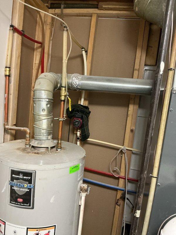 Responded to plumbing leak involving hot water circulation system. Upon inspection, identified leak at circulation pump and associated piping connections near water heater in utility closet. Accessed mechanical space through closet area where HVAC ductwork and plumbing systems are located. Examined water heater installation with PEX supply lines (red hot, blue cold, white circulation) and circulation pump mounted on piping system. Tightened fittings at pump connections and galvanized pipe joints where leak was occurring. Verified all connections at water heater top including brass fittings and metallic elbow joints for proper seal. Tested system operation and confirmed no active leaks present. Hot water circulation restored to normal function throughout home.
