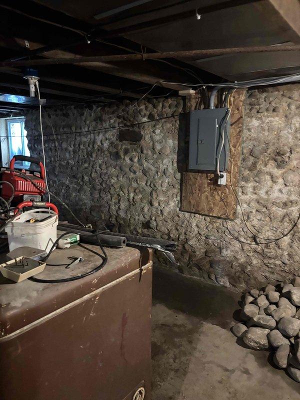 Responded to emergency call for water spraying from top of 15-year-old water heater in basement with stone foundation. Upon inspection, identified failed temperature and pressure relief valve as source of leak. Shut off water supply, drained unit partially, replaced defective T&P valve, and tested system for proper operation and no additional leaks.