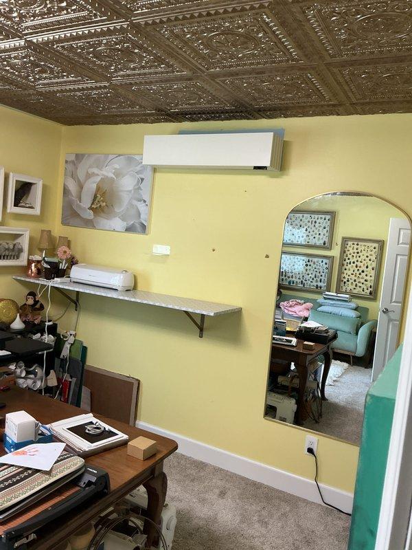 Completed installation of multi-zone ductless mini-split system in residential property. Installed indoor wall-mounted air handler units in multiple rooms including office/living area with decorative tin ceiling and bedroom with crown molding. Mounted units at optimal heights for efficient air distribution, ensuring proper clearance from ceiling and adequate drainage routing. Verified electrical connections, refrigerant line sets, and condensate drainage for all zones. Tested system operation across all indoor units, confirmed proper cooling function, and programmed individual zone controls. System commissioned and left fully operational per manufacturer specifications.