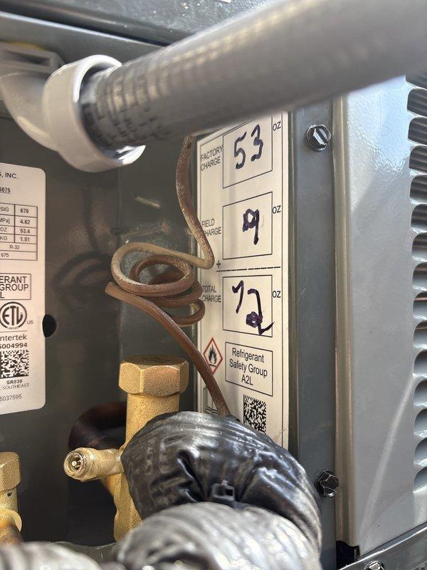 Complete air conditioning system replacement performed at residential property. Removed existing outdoor condensing unit and installed new HVAC condenser on concrete pad between exterior walls. Unit positioned with proper clearances from building structures and electrical disconnect box. 

System startup procedures completed including refrigerant charging verification using manifold gauges with digital readout. Factory charge levels confirmed and documented at charging ports. All refrigerant connections pressure-tested and sealed. Copper refrigerant lines properly insulated and secured. System cycled through complete operation to verify proper function of condenser fan motor and compressor. Final system diagnostics confirmed proper pressures and operational parameters within manufacturer specifications.