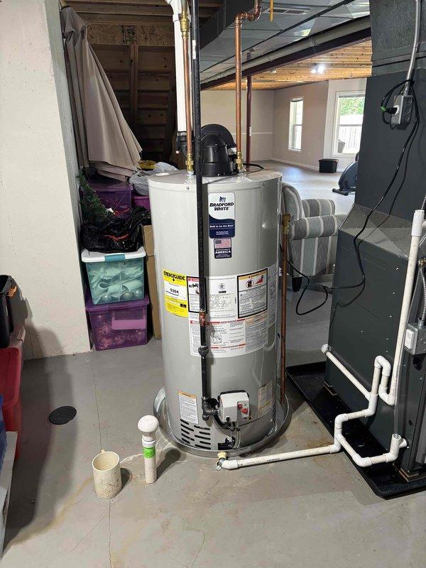 Completed installation of Bradford White residential water heater in basement utility area. Installed new unit with proper copper supply line connections and configured all plumbing connections to code. Verified proper venting, tested all connections for leaks, confirmed unit operation, and ensured safe clearances from adjacent HVAC equipment and storage areas.