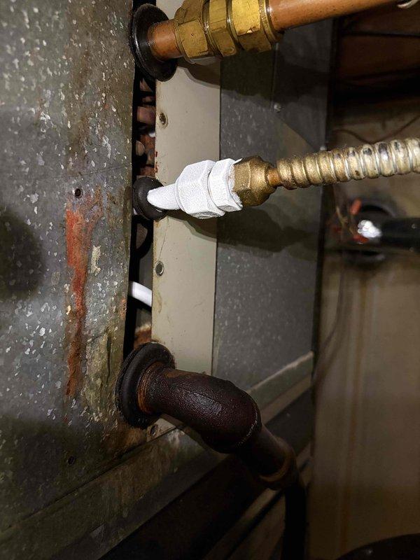 Responded to no cooling complaint on residential air conditioning system. Upon arrival, conducted thorough inspection of HVAC unit and associated components. Examined refrigerant lines, gas connections, and mechanical fittings in utility area. Observed aging copper piping with corrosion and oxidation, brass compression fittings showing surface wear, and corrugated stainless steel flexible gas line with proper thread seal tape application. Documented existing conditions of plumbing infrastructure and connections to heating/cooling equipment. Verified all gas line connections were secure with appropriate sealing. System evaluated for proper airflow and mechanical operation. Photos captured of pipe connections, brass fittings, and utility area components for service records. Unit restored to normal cooling operation.