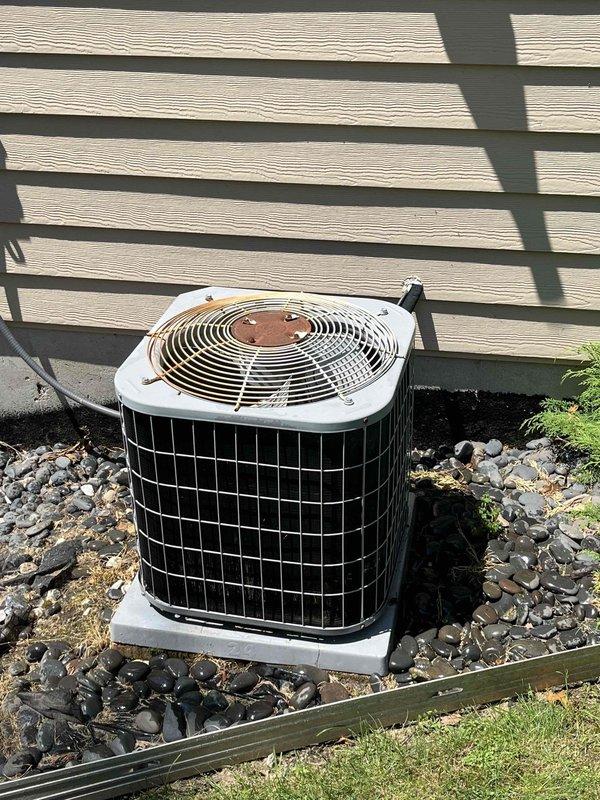 Completed annual cooling maintenance on Carrier outdoor condensing unit manufactured in 2021. Performed comprehensive system inspection including visual assessment of condenser cabinet, fan assembly, and refrigerant lines. Unit located on concrete pad with adequate clearance, though minor debris accumulation noted in surrounding landscape rock. Fan grille showed signs of surface oxidation but remains structurally sound. Verified proper electrical connections and conduit routing to building exterior. All components operating within normal parameters. Updated customer contact information in service records.