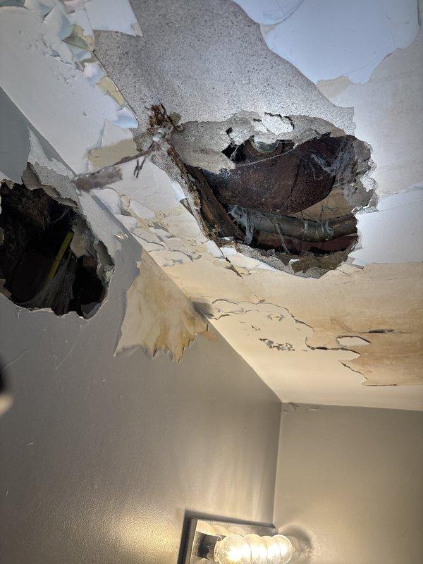 Responded to service call for garbage disposal removal and leaking toilet. Upon arrival, discovered significant water damage to ceiling with multiple collapsed sections and extensive staining, indicating prolonged leak from bathroom above. Removed existing garbage disposal unit from kitchen sink as requested. Inspected under-sink plumbing connections and cleared cabinet area for access. Assessed toilet leak source and documented ceiling damage caused by water intrusion from failed toilet seal or supply line. Photographed affected areas showing structural compromise to ceiling drywall and water staining patterns. Advised customer of extent of water damage requiring drywall repair and recommended further inspection of bathroom floor and subfloor integrity before ceiling restoration.