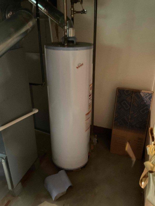 Responded to service call for failed gas water heater that would not light pilot, leaving residence without hot water. Inspected 15-year-old conventional tank-style gas water heater and confirmed unit failure. Evaluated existing installation including copper supply lines, gas connections, venting system, and pressure relief valve configuration. Documented current setup with photographs showing plumbing connections, ductwork, and surrounding utility space layout. Provided consultation and prepared comprehensive estimates for two replacement options: tankless on-demand water heater installation and traditional tank-style gas water heater replacement to allow comparison of both solutions.