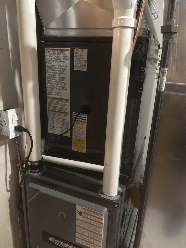 Successfully completed full HVAC system installation including new furnace and air conditioning unit. Installed black air handler unit with gray furnace in basement mechanical room with proper clearances and professional ductwork connections. Exterior condenser unit mounted on concrete pad with electrical disconnect, conduit, and proper utility connections installed per code. All PVC condensate drain lines, refrigerant lines, and electrical connections completed. System tested and verified operational. Installation includes organized piping runs, adequate equipment clearances, and all manufacturer specifications met for residential heating and cooling system.