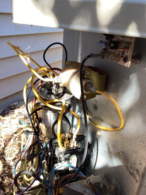 # Carrier AC Intermittent Cooling Issue - Condenser Fan Failure

Responded to service call for Carrier air conditioning system experiencing intermittent cooling loss affecting entire home. Customer reported that when unit failed to produce cold air, outdoor condenser fan was not operating.

Upon arrival, performed visual inspection of outdoor condensing unit. Observed exposed electrical connections and wiring at unit exterior. Multiple wire connections visible including power supply lines and control wiring in various colors. Unit showed signs of previous service work with accessible electrical components.

Conducted diagnostic testing to identify root cause of intermittent condenser fan operation. Checked electrical connections at outdoor unit for loose or corroded terminals. Inspected fan motor wiring, capacitor connections, and contactor operation. Tested voltage supply to fan motor during call for cooling to verify power delivery during failure mode.

Identified faulty component pr