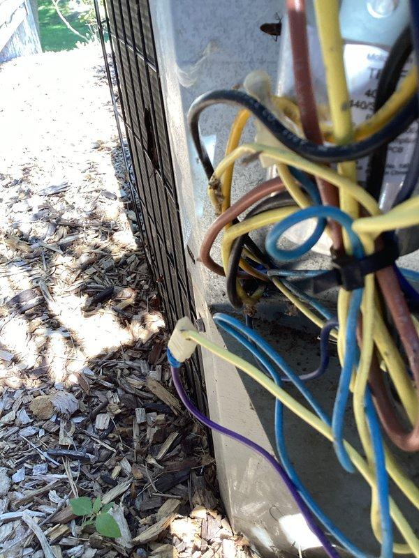 # Carrier AC Intermittent Cooling Issue - Condenser Fan Failure

Responded to service call for Carrier air conditioning system experiencing intermittent cooling loss affecting entire home. Customer reported that when unit failed to produce cold air, outdoor condenser fan was not operating.

Upon arrival, performed visual inspection of outdoor condensing unit. Observed exposed electrical connections and wiring at unit exterior. Multiple wire connections visible including power supply lines and control wiring in various colors. Unit showed signs of previous service work with accessible electrical components.

Conducted diagnostic testing to identify root cause of intermittent condenser fan operation. Checked electrical connections at outdoor unit for loose or corroded terminals. Inspected fan motor wiring, capacitor connections, and contactor operation. Tested voltage supply to fan motor during call for cooling to verify power delivery during failure mode.

Identified faulty component pr