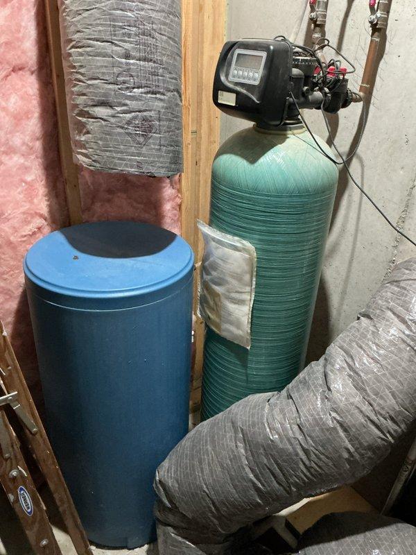 Responded to water quality concerns by conducting comprehensive assessment of existing water treatment infrastructure. Documented hydronic heating system with manifold assembly, copper distribution piping network, and water heater installation in mechanical room. Inspected and photographed water filtration system consisting of dual-tank configuration including softener unit with digital control head and secondary treatment tank with bypass valving and copper supply connections. Verified operational status of equipment and provided client with photographic documentation of current system condition for quality evaluation purposes.
