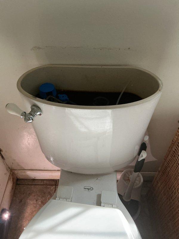 Responded to a service call for two separate toilet issues in the residence. Inspected both fixtures and identified minor plumbing problems requiring attention. Removed tank lid from one toilet to access and evaluate internal fill valve mechanism and flush components. Documented conditions with photos showing mineral buildup and component wear. Provided customer with repair options and membership program information for ongoing plumbing maintenance needs.