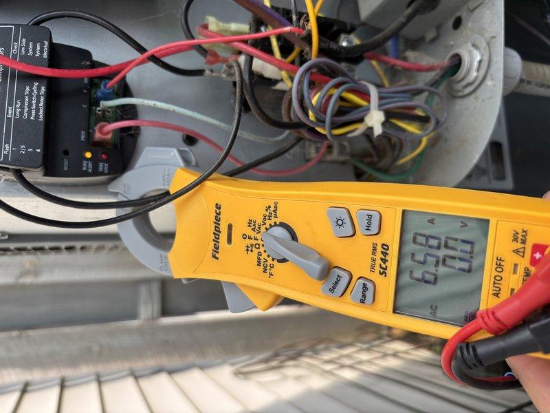 Responded to no cooling complaint on residential air conditioning system. Upon arrival, performed electrical diagnostics on outdoor unit using digital multimeter and clamp meter. Measured voltage at contactor and capacitor connections, reading 6.69V at control board wiring and 5.9A at compressor circuit. Tested all electrical components including contactor, capacitor, and associated wiring connections. Documented findings with photographs showing voltage and amperage readings during diagnostic process. System evaluated for proper electrical supply and component functionality to identify root cause of no cooling condition.