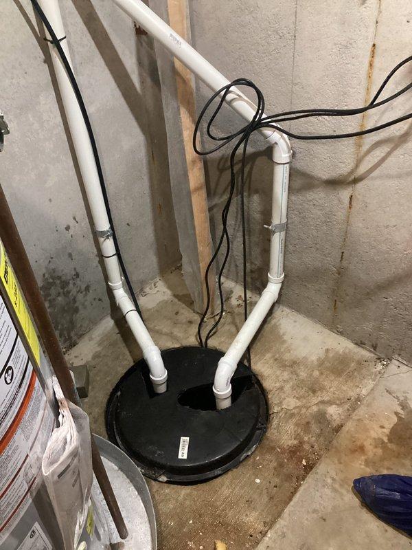 Responded to sump pump discharge issue where water was spraying back into the basement through a failed PVC pipe connection at the sump pit. Upon inspection, identified deteriorated connection fittings on the discharge line that had been leaking for approximately two months. Repaired the compromised PVC connection point at the sump basin, ensuring proper seal and secure fitting to prevent water from re-entering the basement area. Verified discharge line integrity from interior sump pit through exterior termination point at foundation, confirming proper drainage flow away from structure. Tested system operation under full pump cycle to confirm leak elimination and proper water evacuation. Documented existing installation configuration including discharge routing and exterior drainage connection. System restored to full operational status with no further water intrusion into basement area.